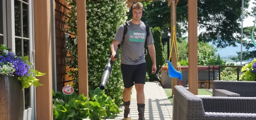 Cleaning around house with a blower