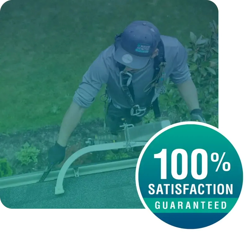 Satisfaction Guaranteed, technician cleaning gutters on a house