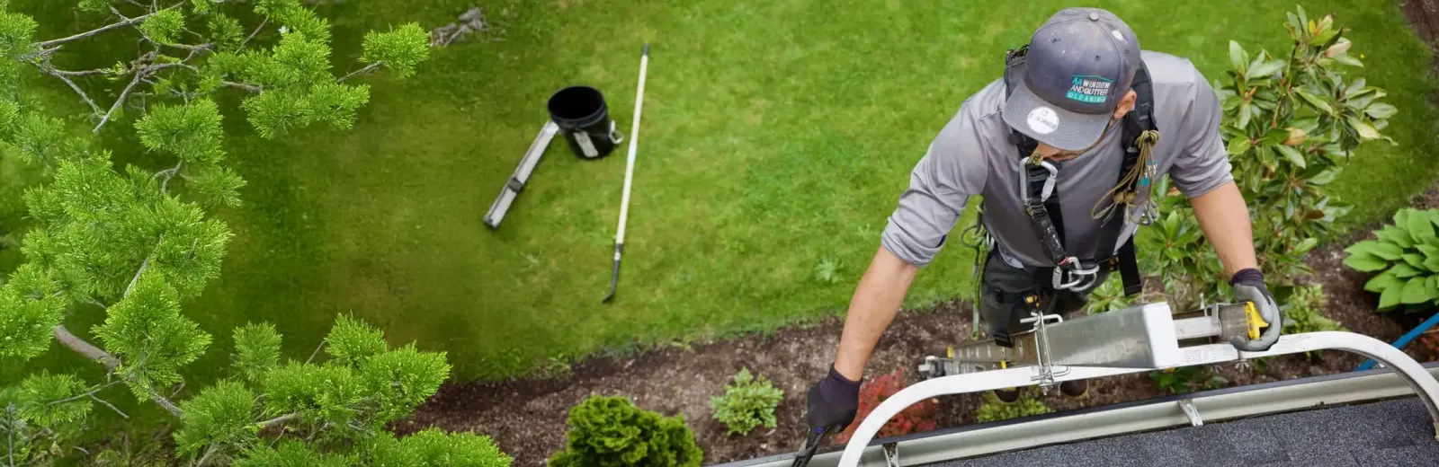 Tech cleaning gutter on house