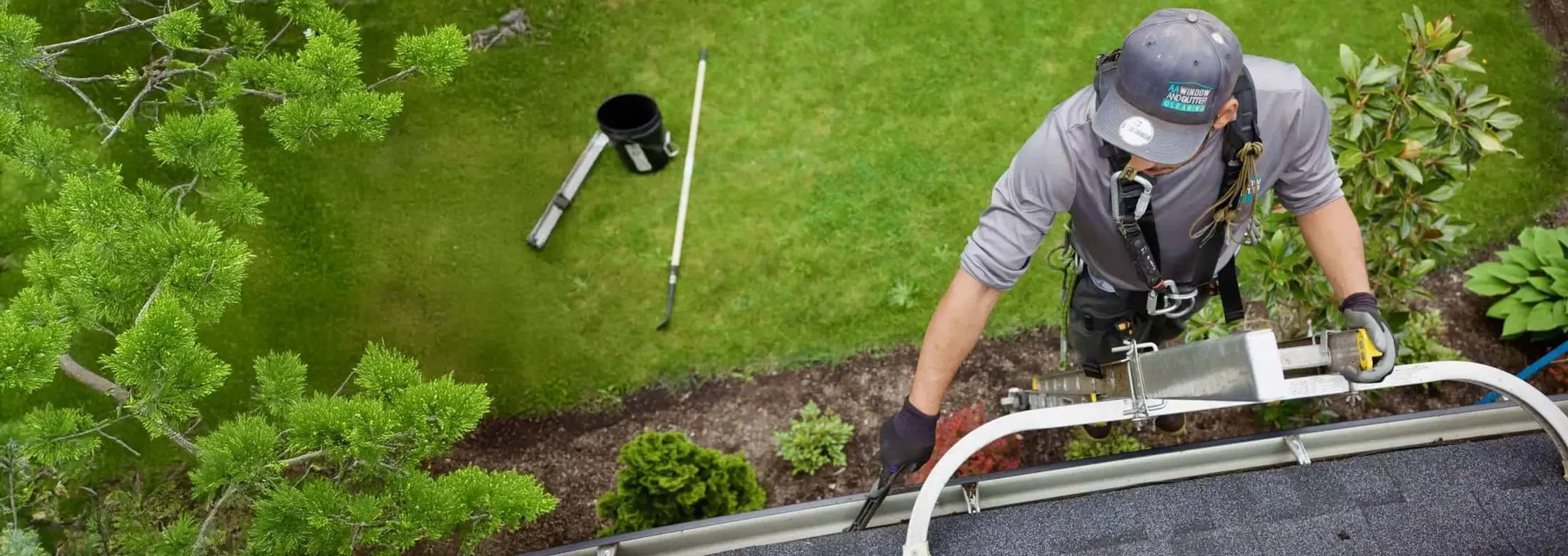Tech cleaning gutter on house
