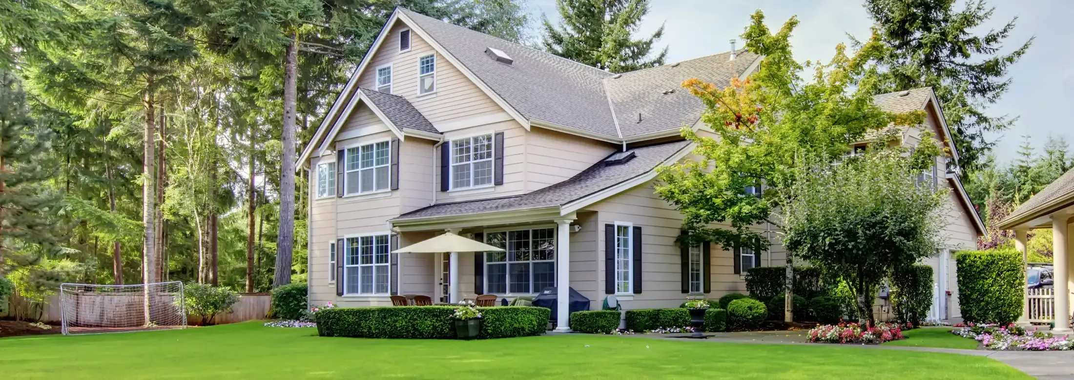 two story traditional house with trees around it